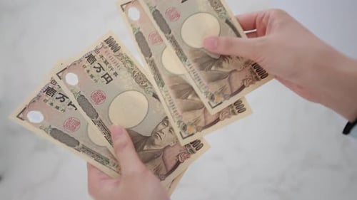 Hands counting Japanese Yen currency