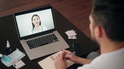 Back View of Man Making Video Call with Doctor While Staying at Home