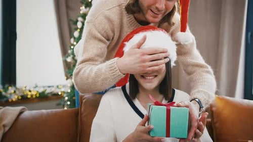 Couple Exchanging Christmas Gift in Cozy Home