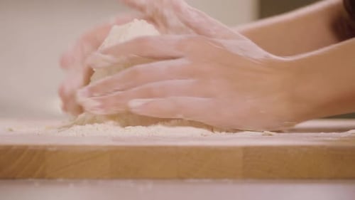 Eine Frau knetet krümeligen Gebäckteig auf einer Küchentheke - Nahaufnahme - Zeitlupe