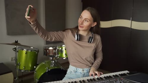 Woman Plays Keyboard While Recording Video