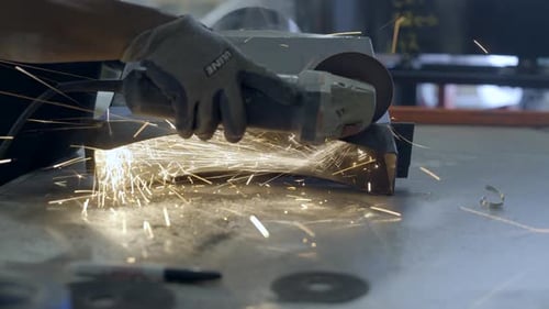Worker cutting a part of oven in workshop