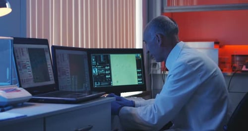 Scientist Taking Notes at Computer Screen
