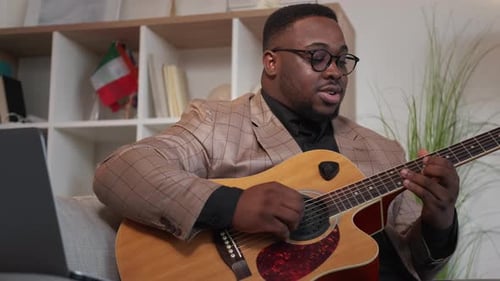 Man Playing Acoustic Guitar and Singing Indoors