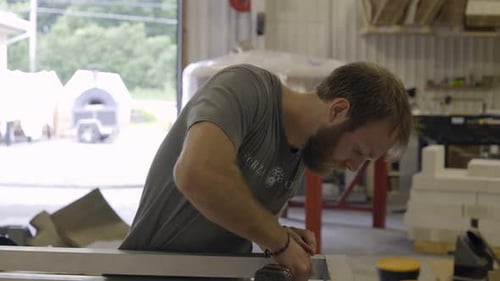 Medium shot of worker drilling holes in sheet metal
