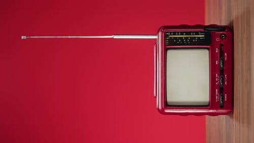 Hand Turns on Vintage Red Television with Static