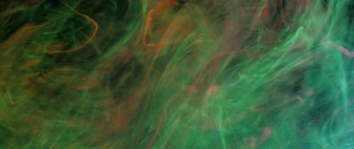Orange green and pink glowing ink swirling
