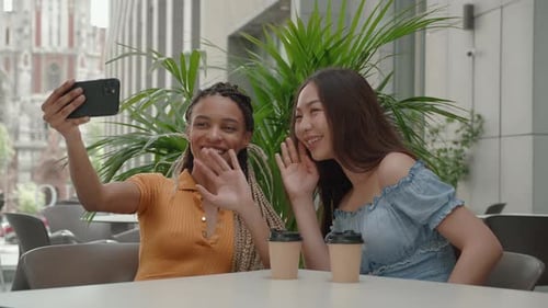 Two Friends Taking a Selfie at Outdoor Cafe