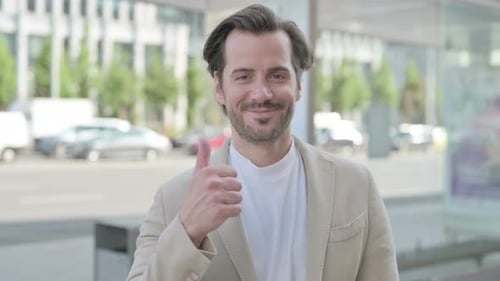 Smiling Man Gives Thumbs Up in City Setting