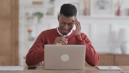 Stressed Man Massaging Temples in Bright Home