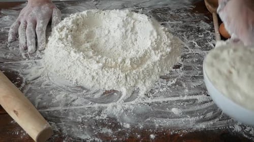 Hands Kneading Dough and Flour on Wooden Table