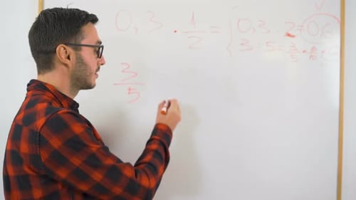 Close Shot of Male Teacher with Glasses Doing Math Class, Writing on Whiteboard with Red Marker