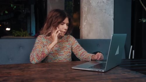 Happy Blogger Girl Talking on Laptop Sitting in Cafe