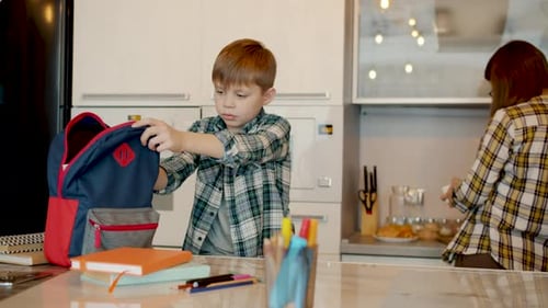 Mother Giving Lunch Box To Kid Kissing Hugging While Son Getting Ready for School