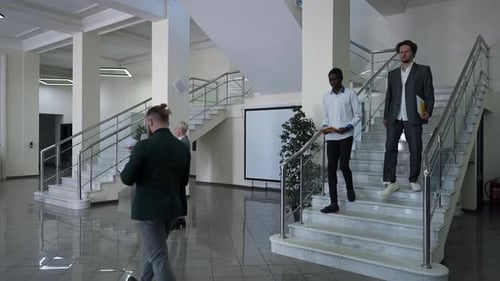 Wide Shot Office Lobby with Busy Multiethnic Men and Women Standing Talking Walking Indoors