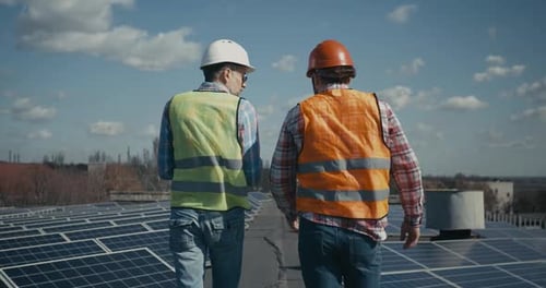 Ingeniero y técnico discutiendo entre paneles solares