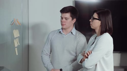 Project Managers Discussing Workflow By Agile Board