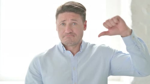 Portrait of Man showing Thumbs Down Gesture
