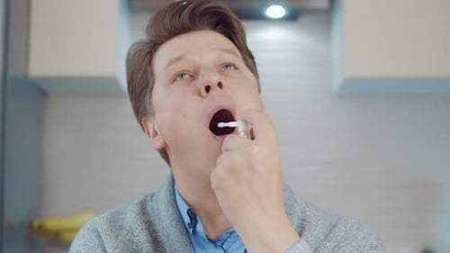 Man Swabs Throat with Diagnostic Swab, Close Up