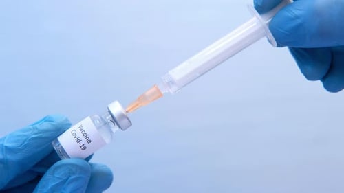 Doctor Hands in medizinischen Handschuhen hält Spritze und Impfstoff.