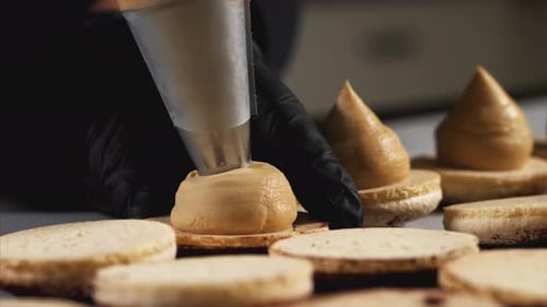 Pastry Chef Icing Gourmet Macaroons in Kitchen