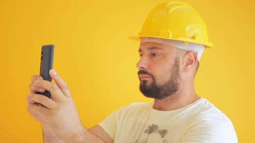 Person with Hard Hat Looking at Cell Phone