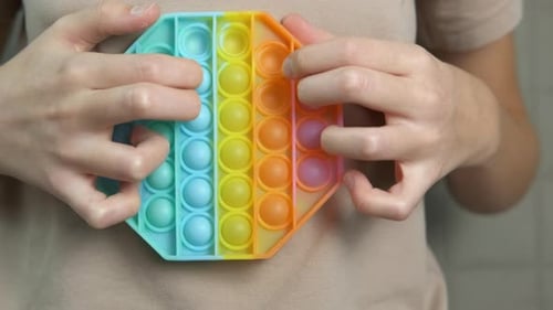Individual Playing with Pop It Fidget Toy