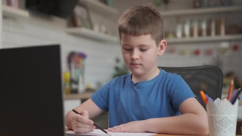 Boy Doing Homework with Laptop at Home