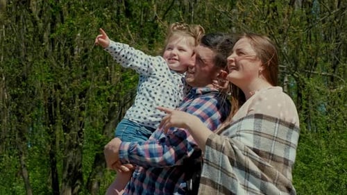Happy Family Resting in Nature Near the Forest