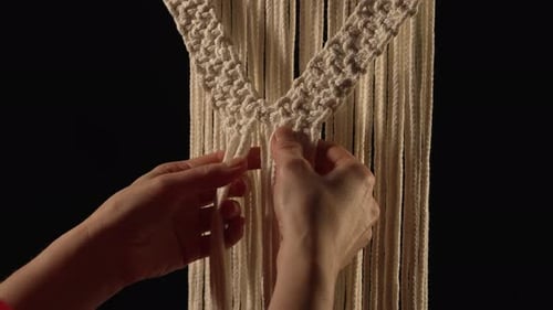 Women's Hands Weave a Macrame Pattern in Creative Workshop on Black Background