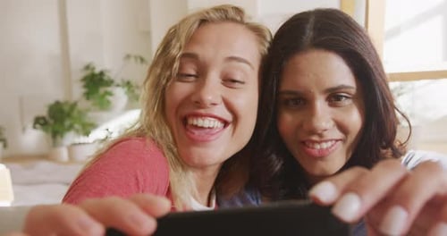 Laughing Women Take Selfie Together Indoors