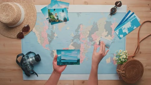 Person Arranging Photos on a World Map