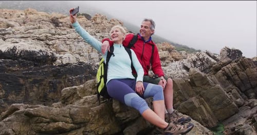 Mature Couple Taking Selfie on Rocky Coast