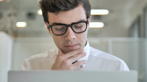 Denkender Geschäftsmann arbeitet am Laptop