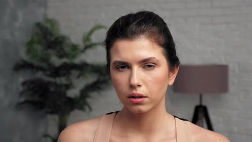 Woman Drinks Water During Home Fitness Workout