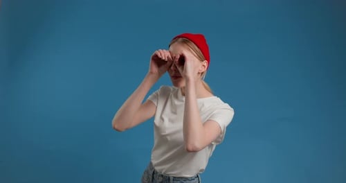 Junge Frau macht Brillenform mit Händen Fernglas Geste