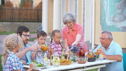 Family Eating Sandwiches Together at a Picnic Table