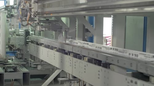 Automated Machine Cutting White Profile on Factory Floor