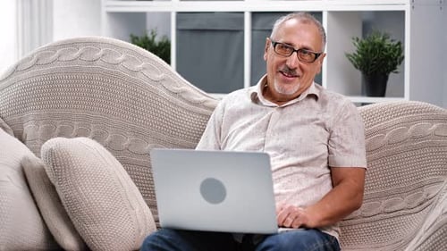 Man Working on Laptop Comfortably on Couch