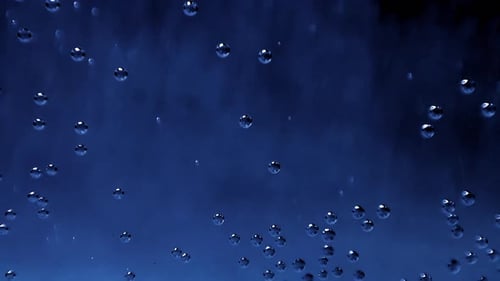 Air Bubbles Flowing Upwards in Blue Liquid