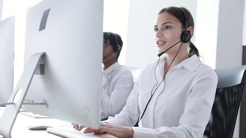 Callcenter. Lächelnde Frau mit Headset arbeitet am Computer
