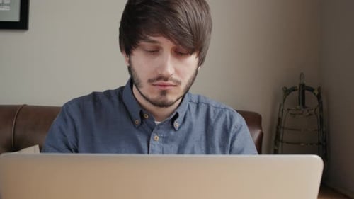 Young Male Freelancer Chatting on Mobile Phone While Sitting Front Open Laptop Computer Cafe