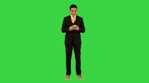 Young Adult on Phone in Front of Green Screen