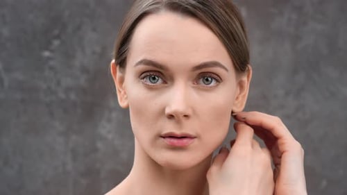 Attractive Young Female Natural Beauty Stroking Naked Body Isolated at Black Studio Background