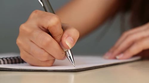 panning shot of hand writing on the paper
