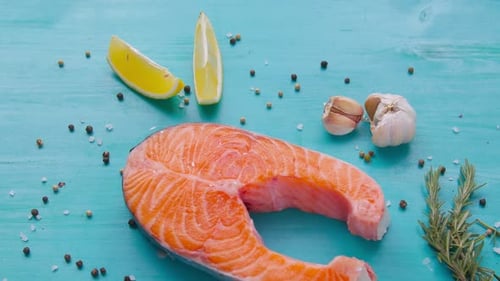 Steak aus rohem Lachs mit Gewürzen auf blauem Hintergrund