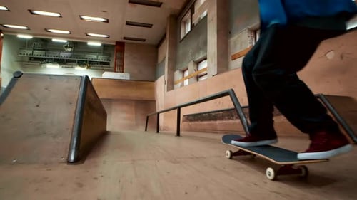 Skateboarder Performs Rail Grind in Indoor Skatepark