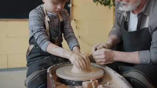 Child Learns Pottery from a Senior Adult