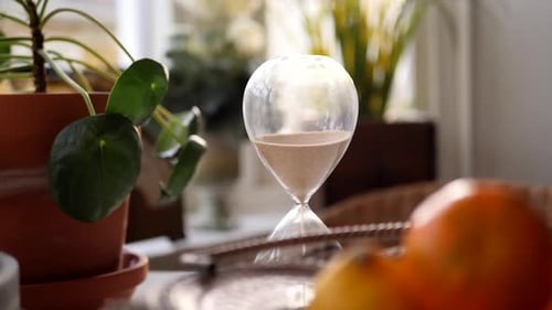 Close-Up of Stylish Hour Glass Next to Plant