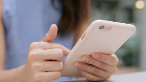 Woman Uses Smartphone with Pink Case